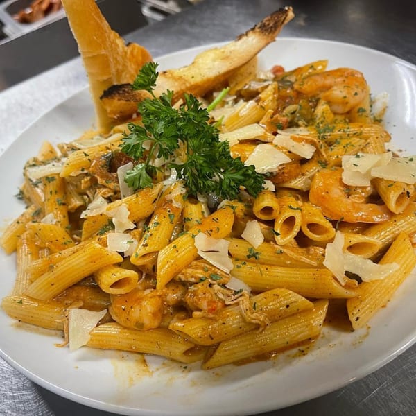 Penne pasta with shrimp, chicken, parmesan, and parsley, served with toasted bread.
