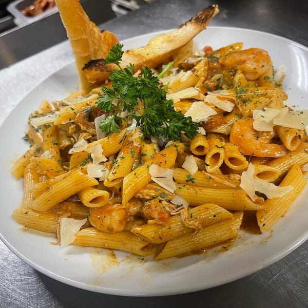 Penne pasta with shrimp, chicken, parmesan, and parsley, served with toasted bread.